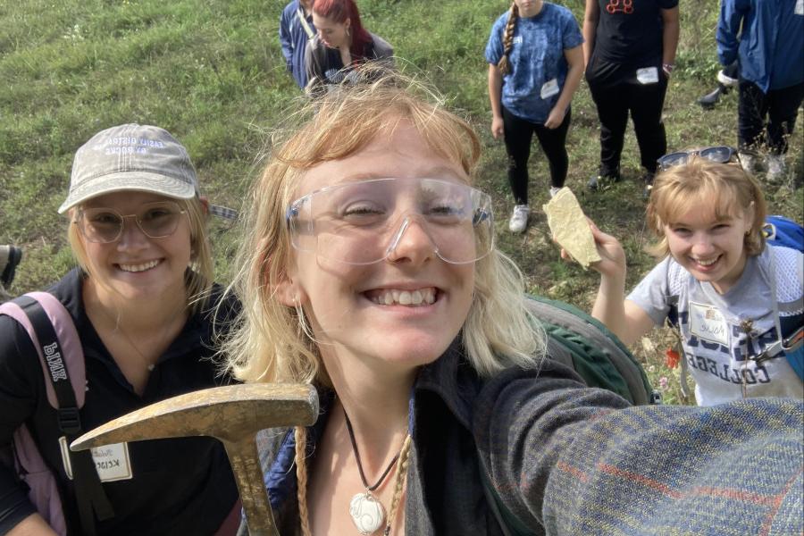 Members of the Geology Club pose together to show off their tools and a rock sample.